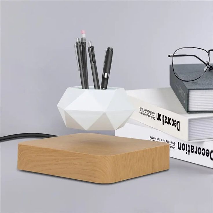 a desk with books, pen holder and glasses on it next to a pair of eyeglasses