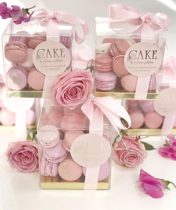 two boxes filled with pink macaroons and roses