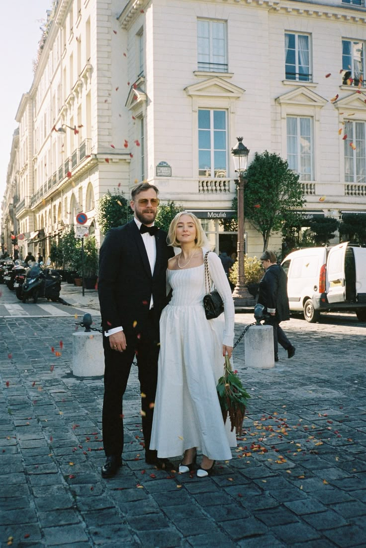 a man and woman standing in front of a building