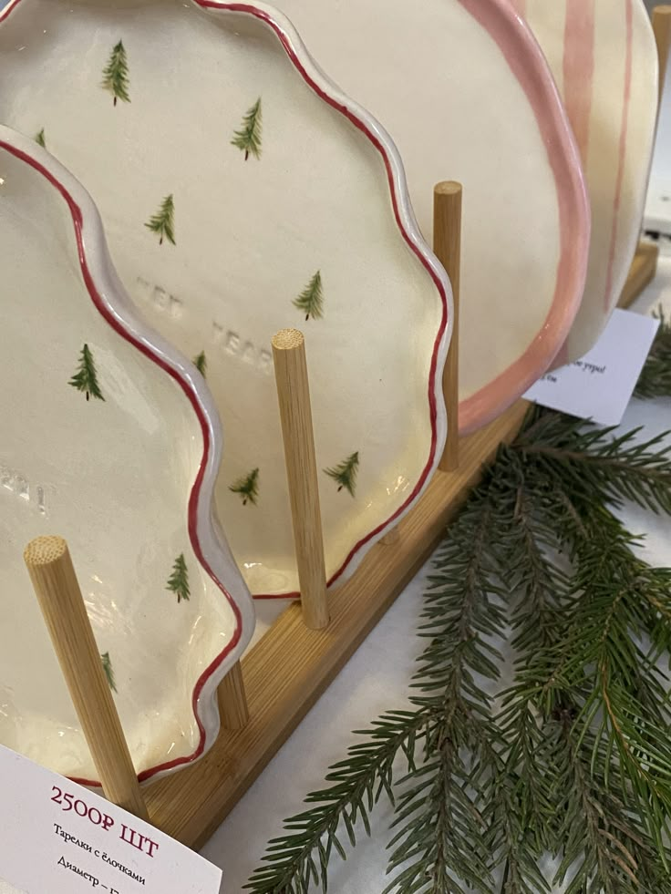 three plates with christmas trees on them sitting on display