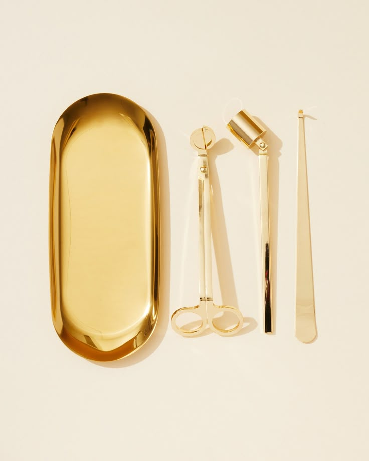 a gold tray, scissors and other items on a white surface