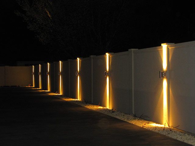 a row of white fences with lights on them