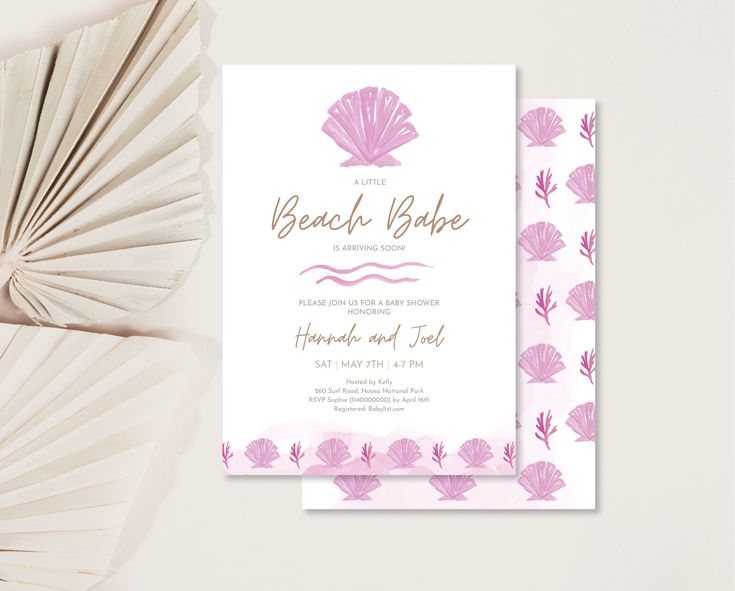 a pink and white wedding card with seashells on it, next to some fan fans