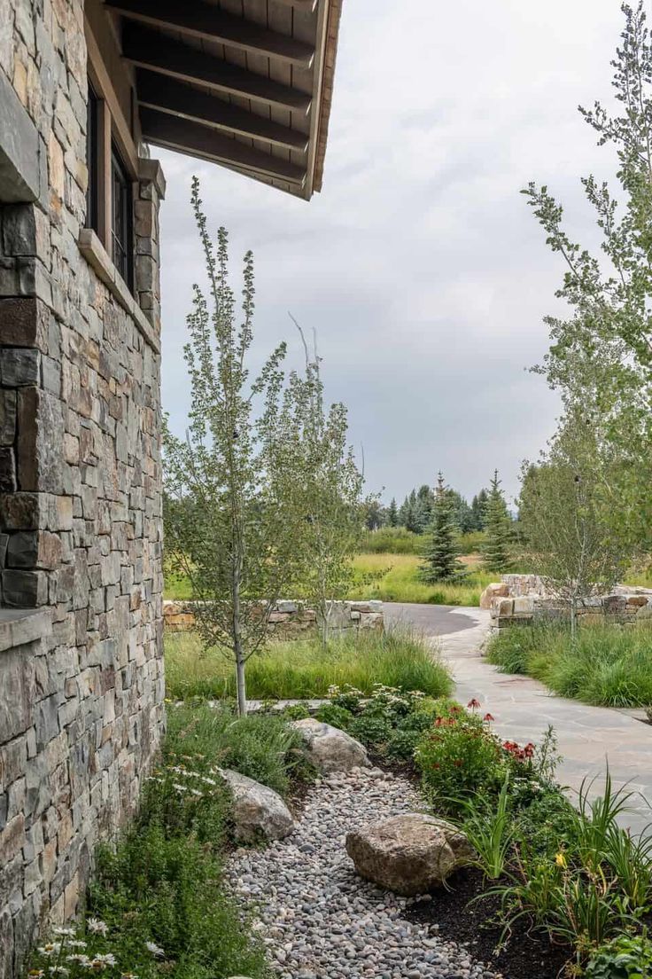 a stone building with plants and rocks on the side