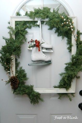 a pair of ice skates sitting on top of a white door with wreath around it