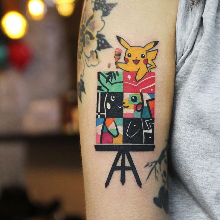 a person with a tattoo on their arm holding a camera and an image of pikachu