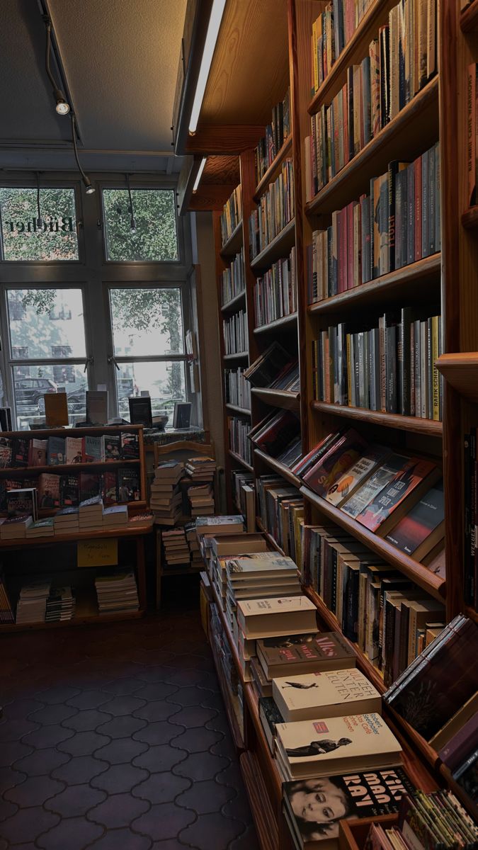 a library filled with lots of books next to a window covered in windowsills