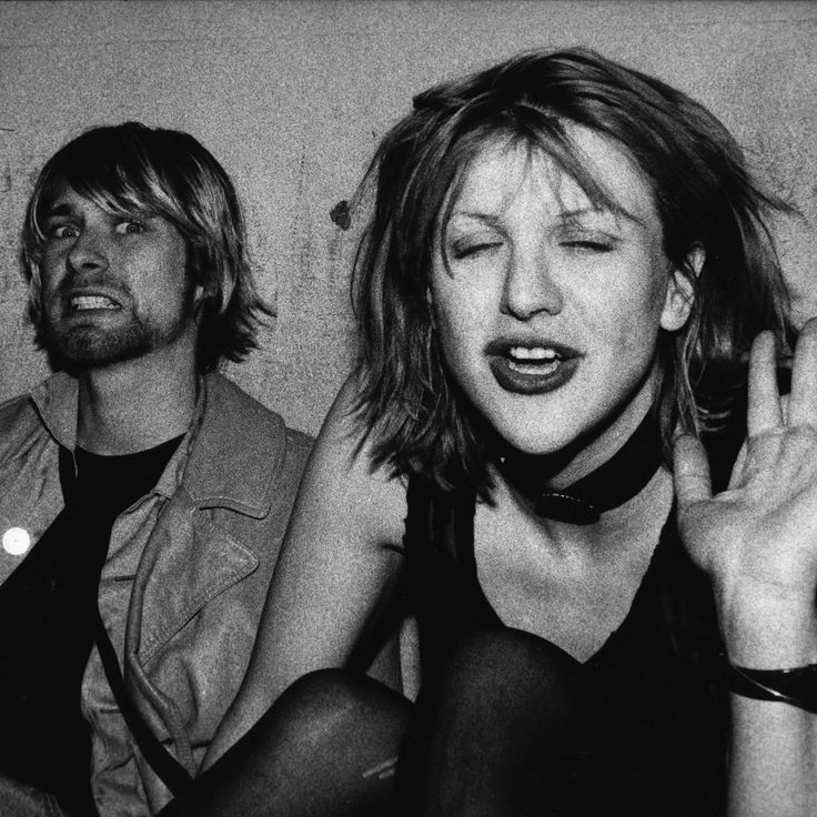 black and white photograph of two people with their hands in the air