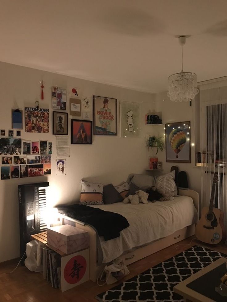 a bed room with a neatly made bed and lots of pictures on the wall