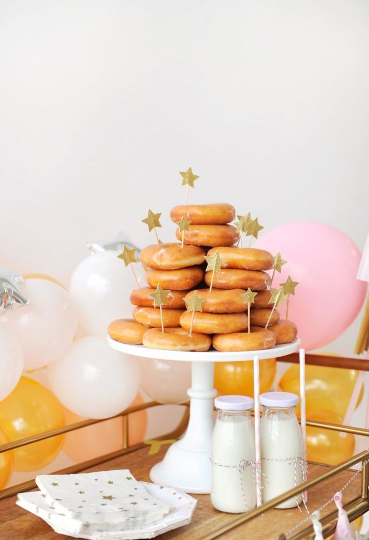 a table topped with lots of doughnuts and balloons