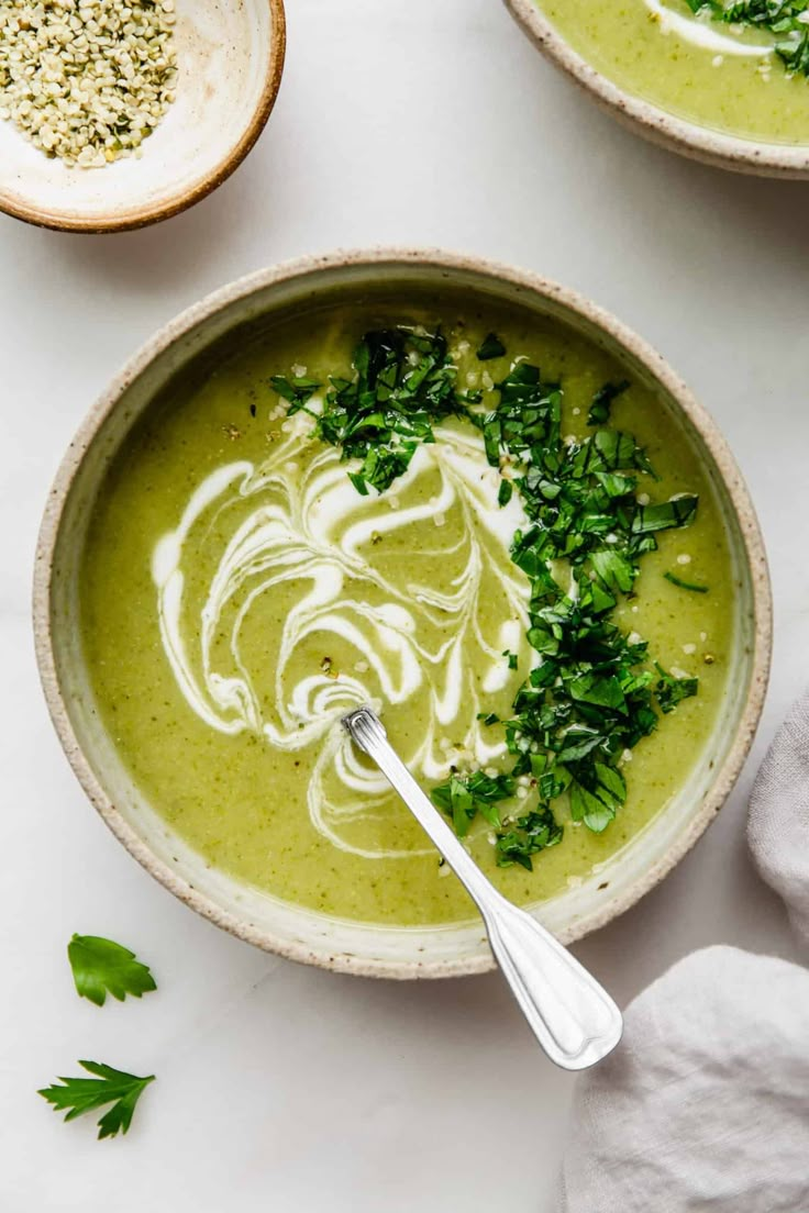 two bowls filled with soup and garnished with parsley