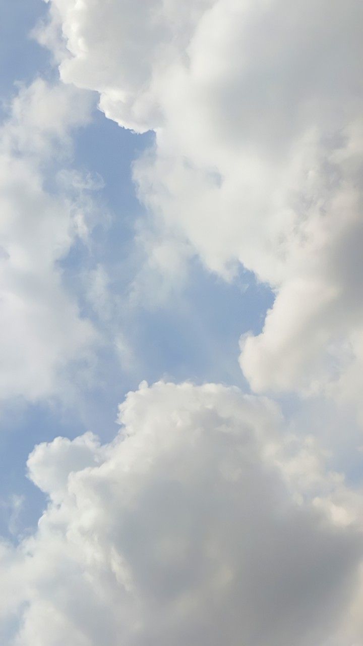 an airplane is flying through the cloudy sky