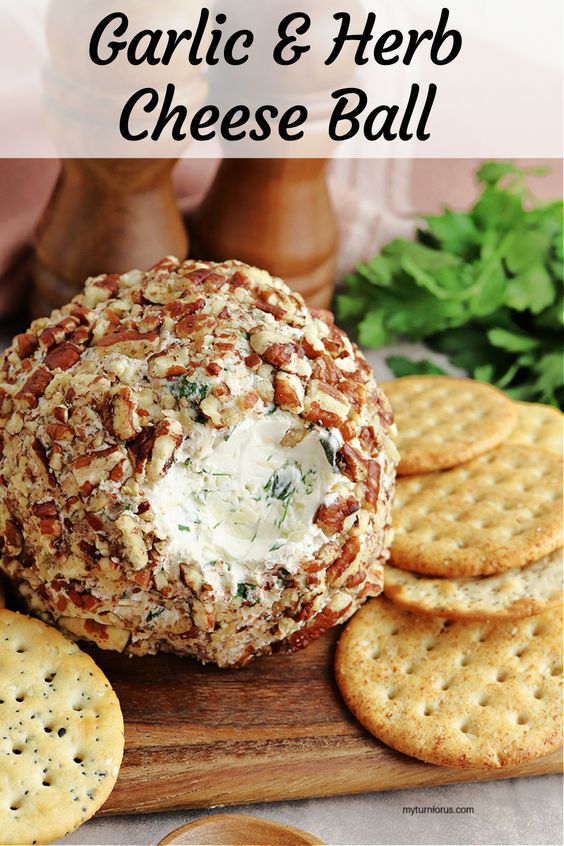 garlic and herb cheese ball on a cutting board with crackers