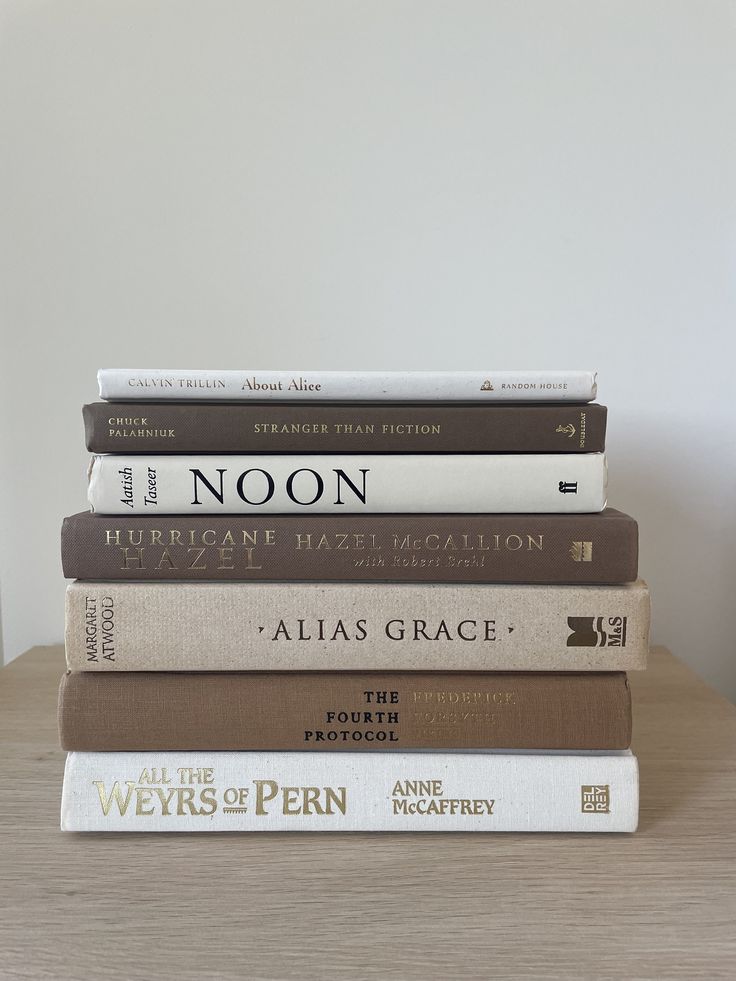 a stack of books sitting on top of a wooden table