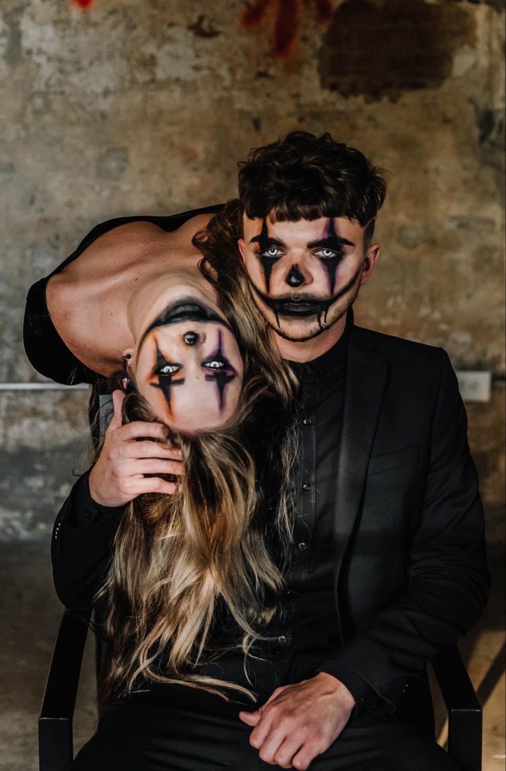 a man and woman with painted faces sitting next to each other