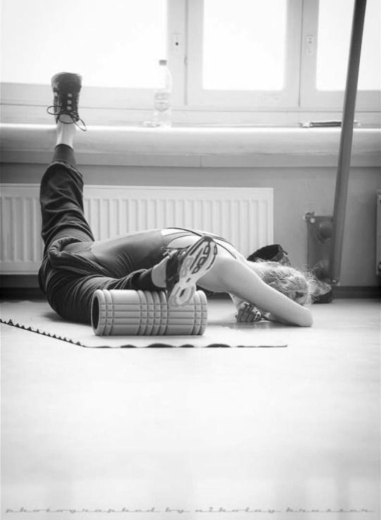 a person laying on the floor with their feet up in the air while holding a cell phone