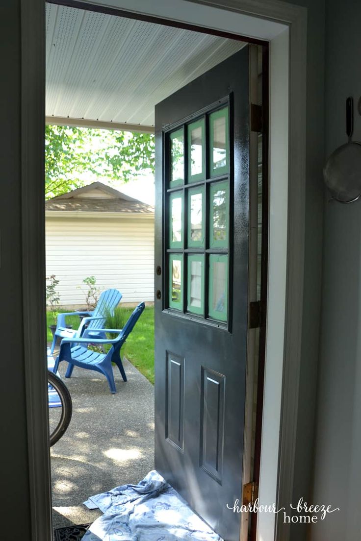 an open door leading to a patio with blue chairs