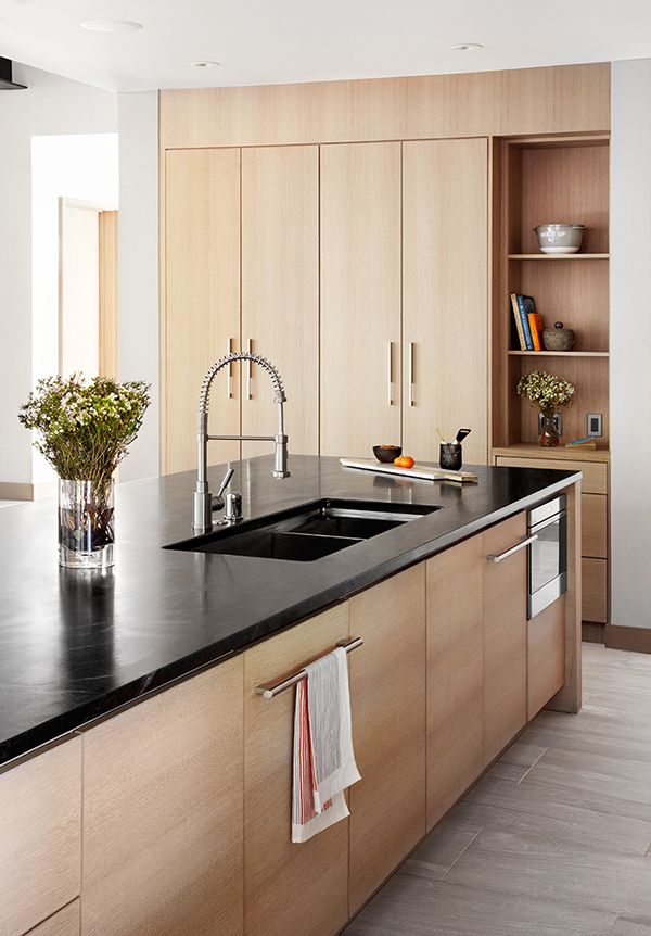 a kitchen with black counter tops and wooden cabinets