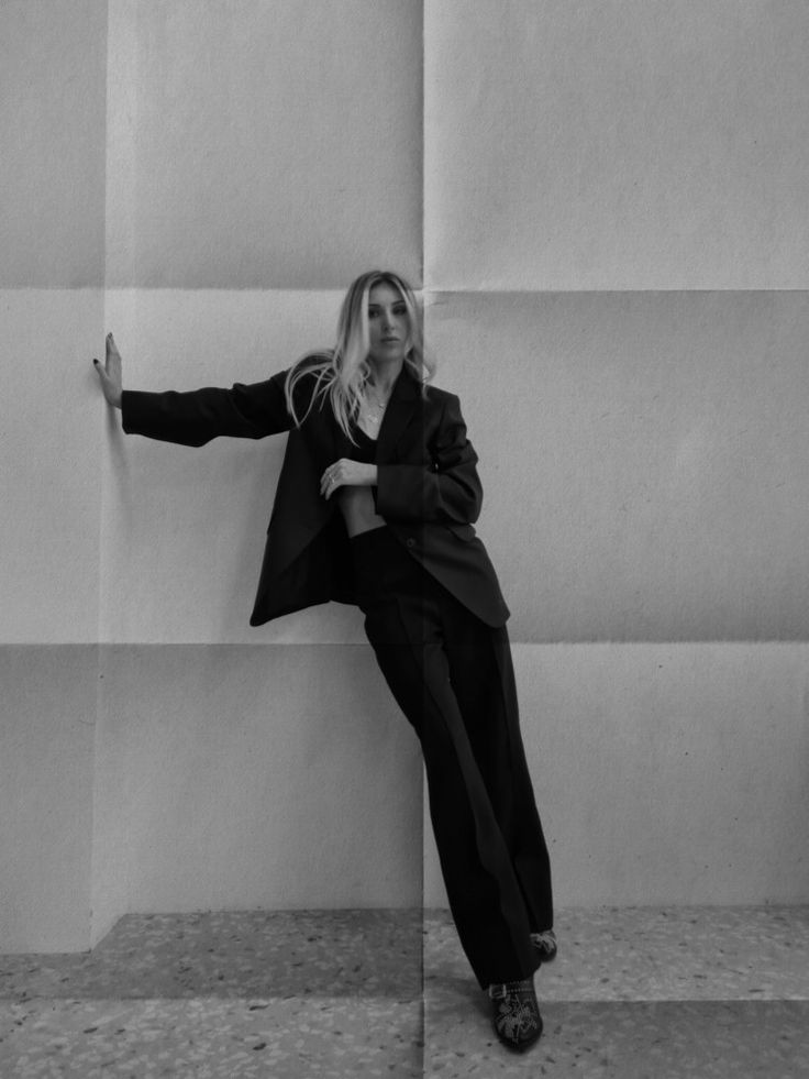 black and white photograph of woman leaning against wall