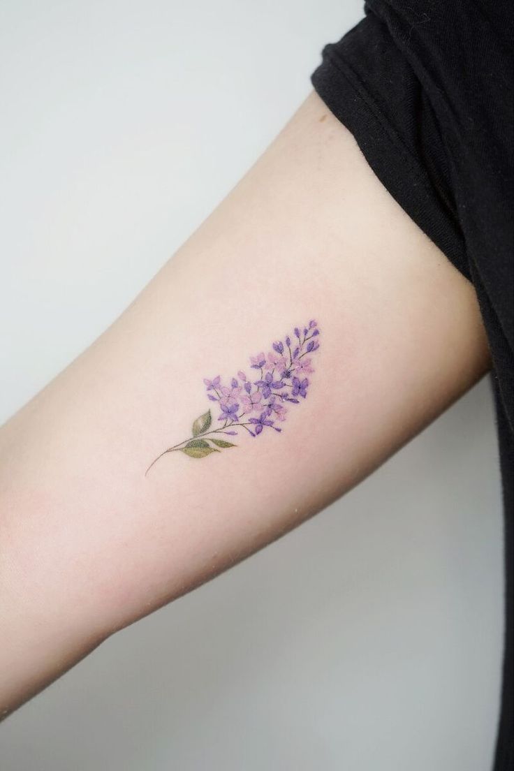 a woman's arm with purple flowers on it