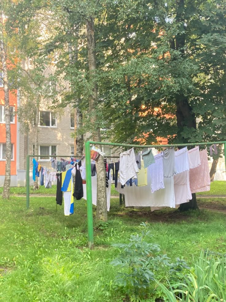 clothes hanging out to dry in the sun on a clothes line outside an apartment building