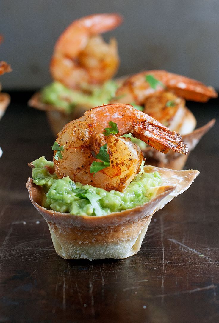 some shrimp and guacamole cups on a table