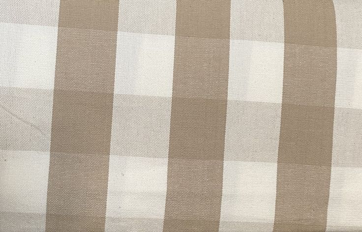 a brown and white checkered pillow on top of a bed