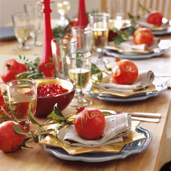 the table is set with plates, silverware and red candles