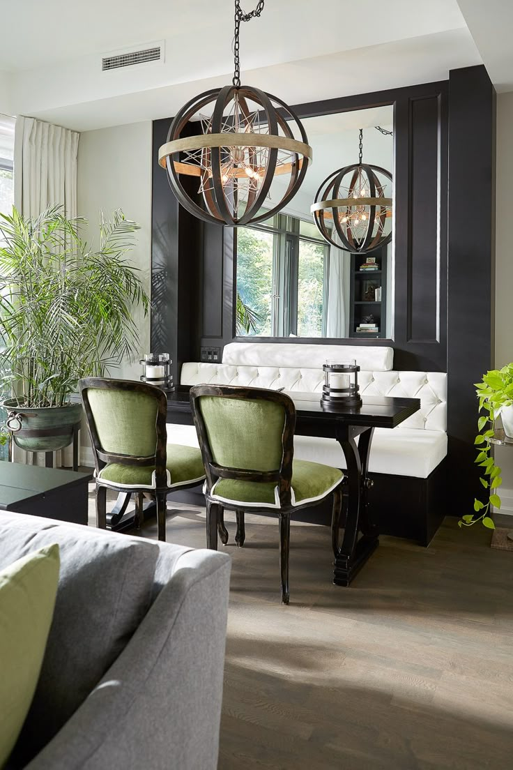 a dining room table with green chairs and a chandelier hanging from the ceiling