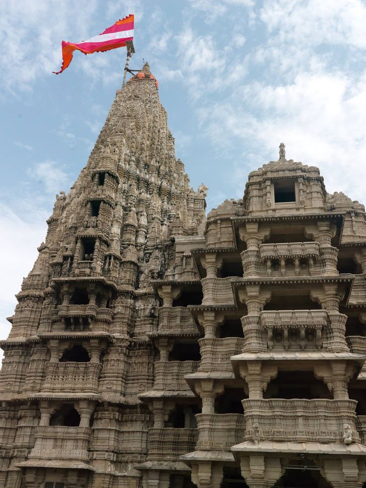 a tall building with many balconies on the side and a flag flying in the air