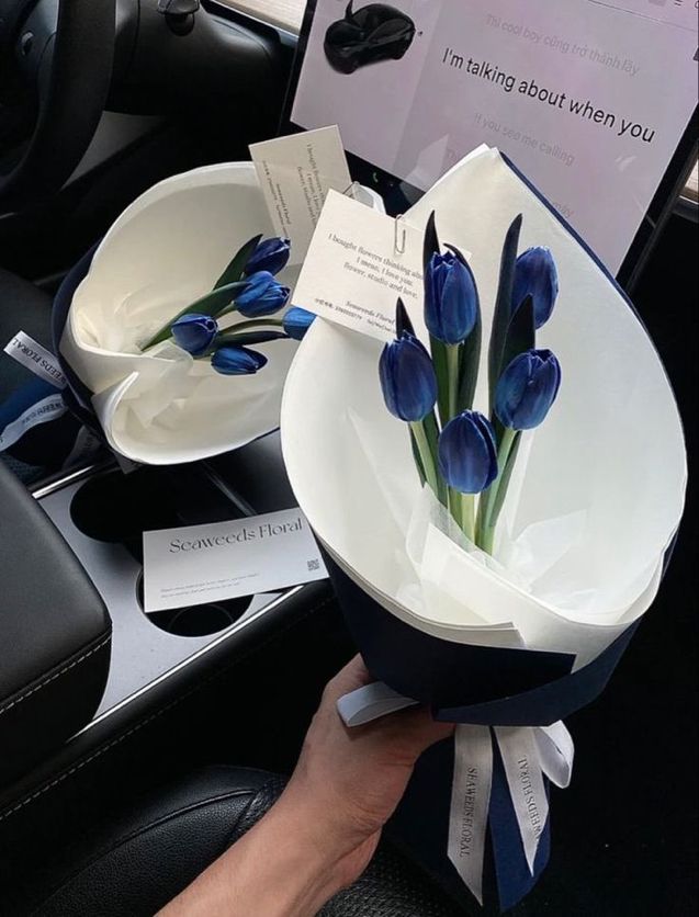 a person holding a bowl with blue flowers in it