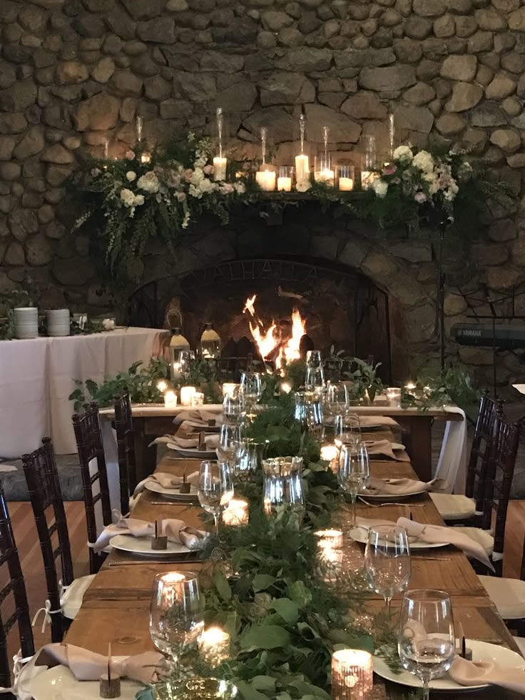 a long table is set with candles and place settings for dinner guests to sit at