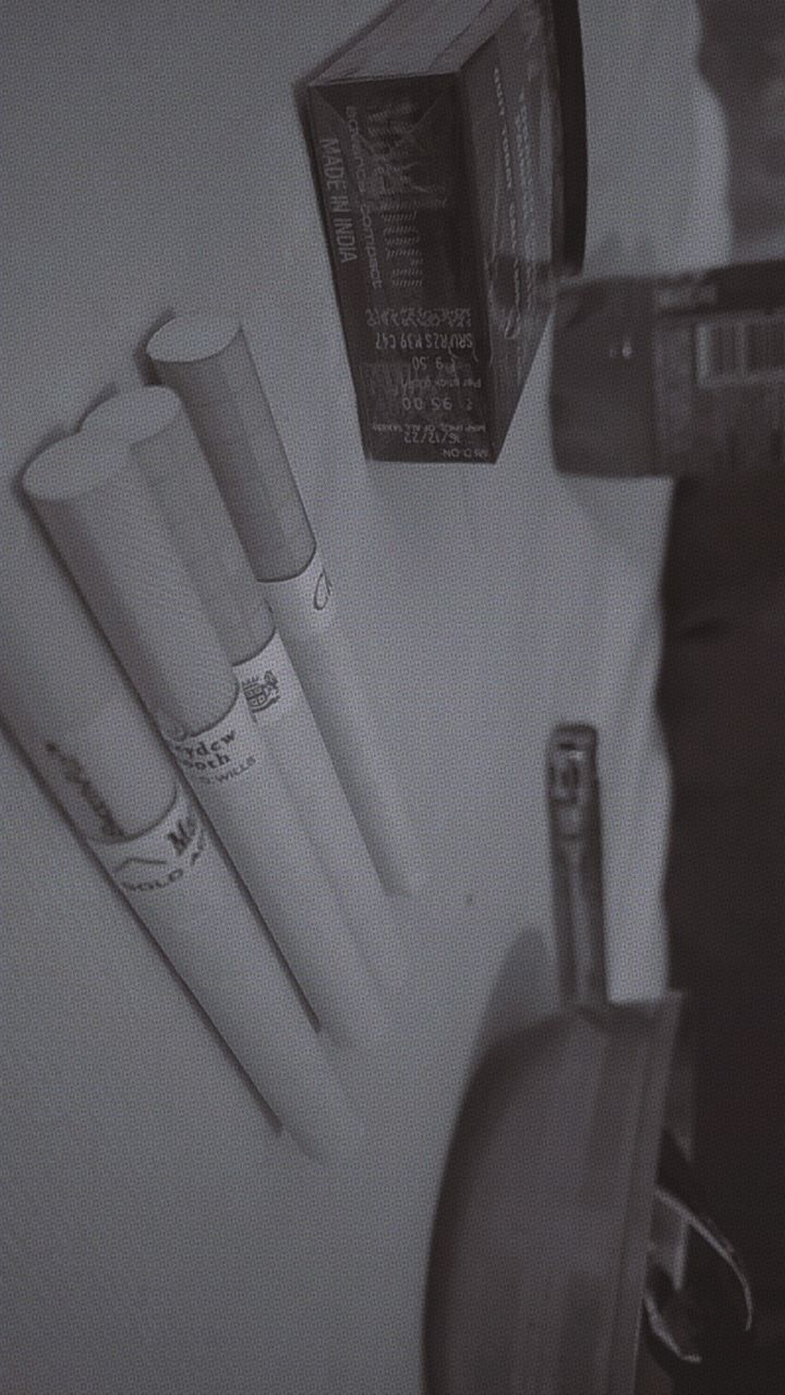 a black and white photo of toothbrushes, an empty bottle and other items