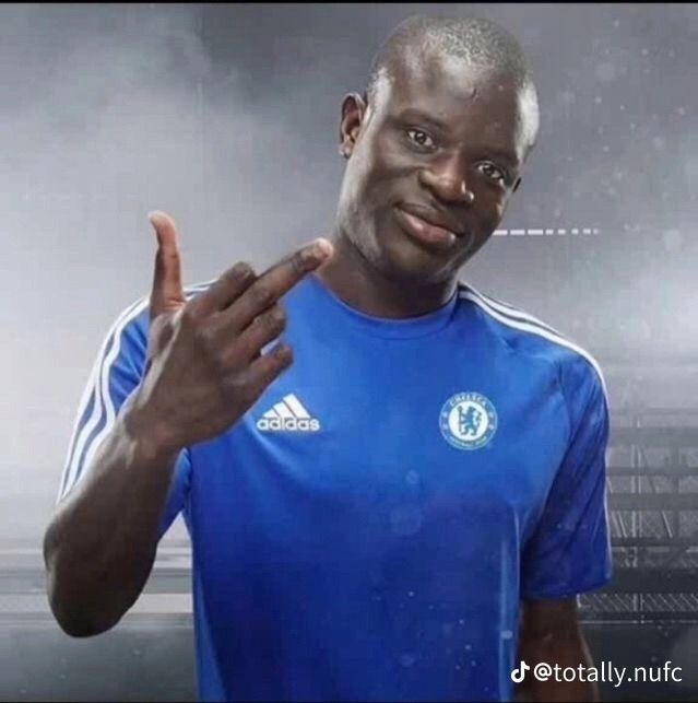 a man in a blue shirt holding his hand up to the camera and making a peace sign