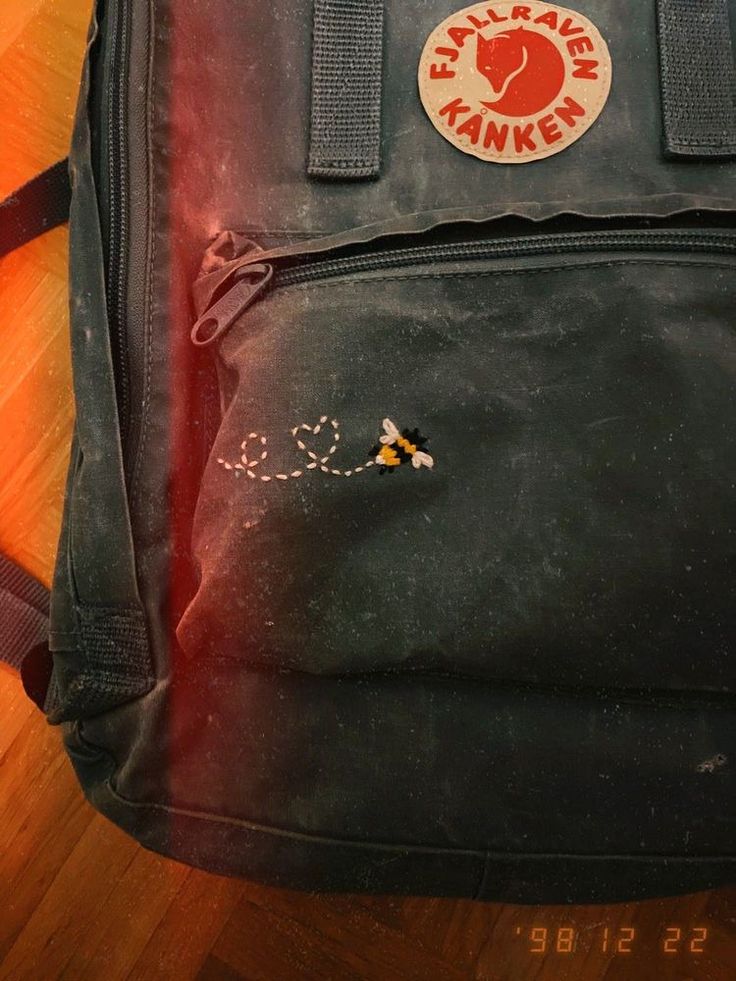 a black backpack sitting on top of a wooden floor