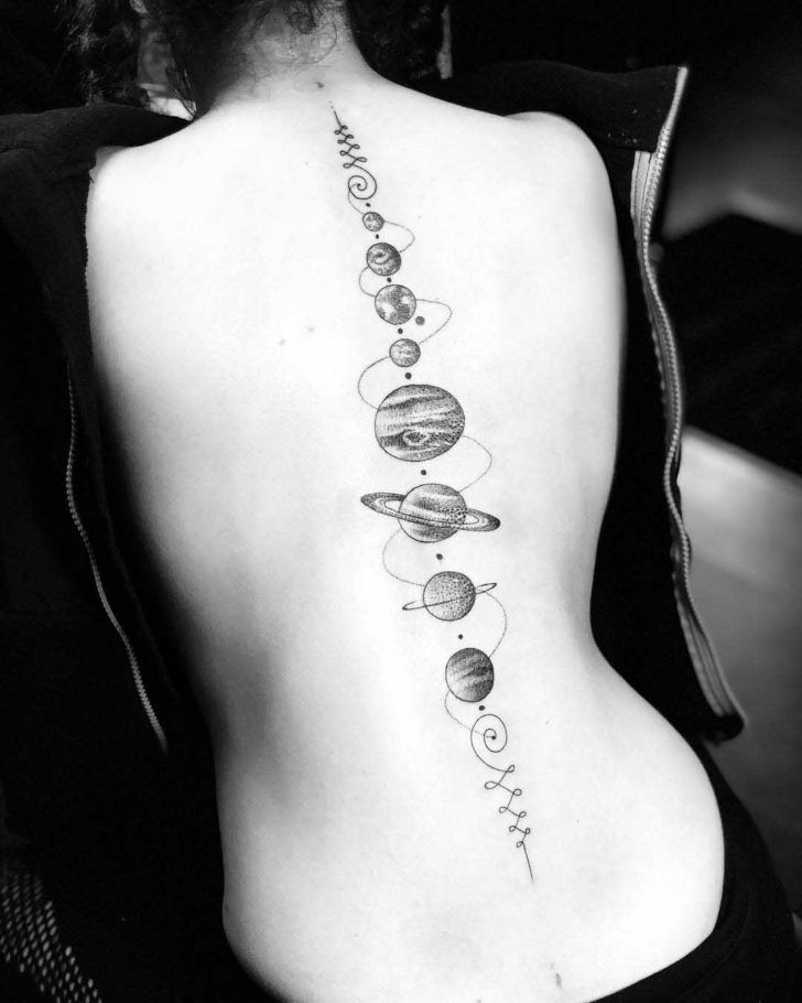 a woman's back with planets and stars on it