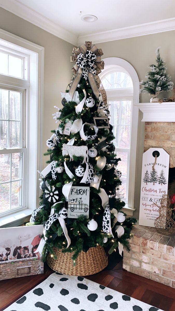 a decorated christmas tree in the corner of a living room with black and white decorations