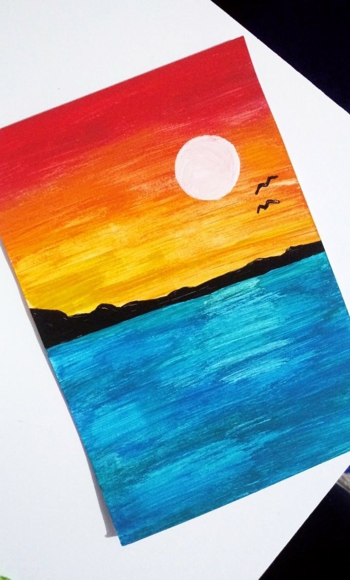 an art project with watercolors and paint on paper, depicting a sunset over the ocean