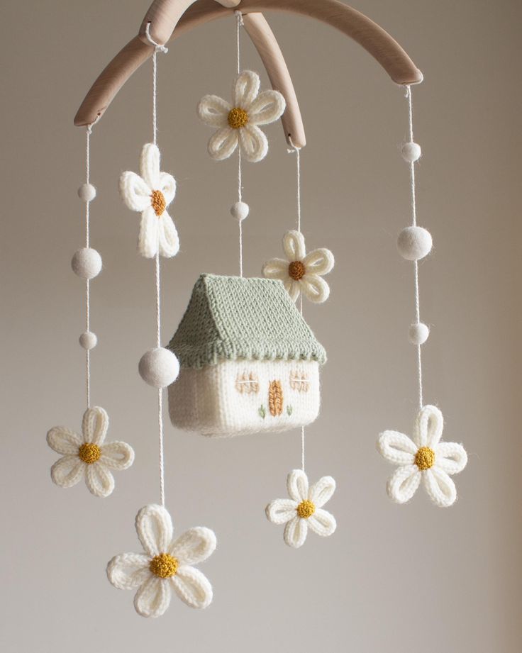 a crocheted house with flowers hanging from it