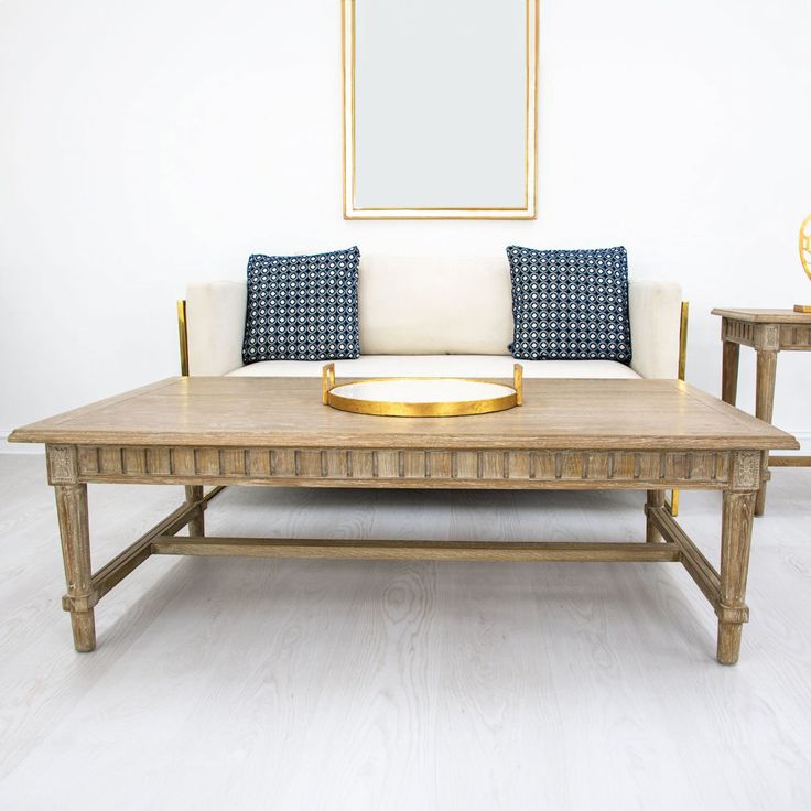 a coffee table with two end tables on each side and a couch in the middle