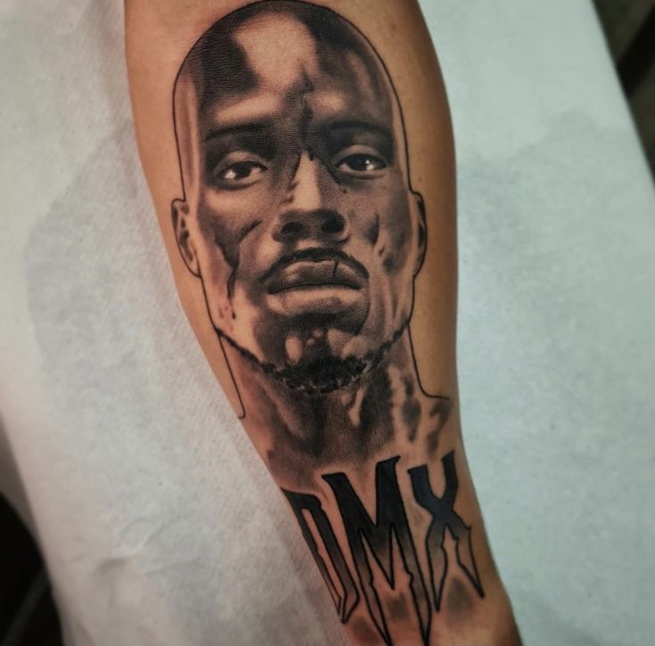 a man's arm with a black and grey ink drawing of him on it