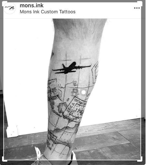 a black and white photo of a person's leg with a plane on it