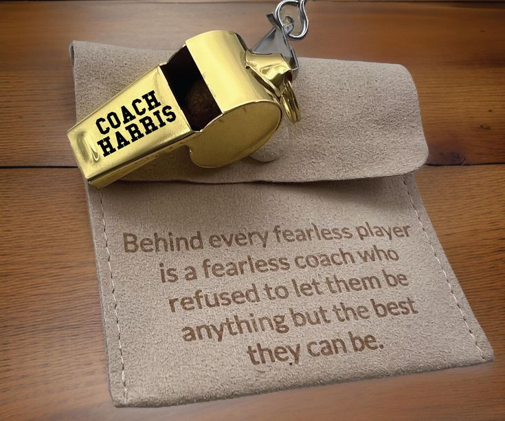 a gold lighter sitting on top of a piece of cloth with a quote written on it