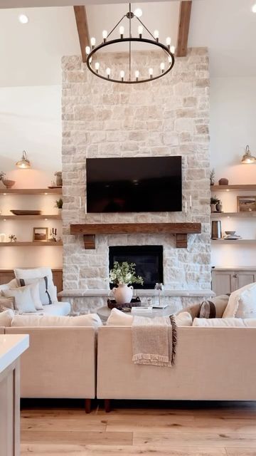 a living room filled with furniture and a flat screen tv mounted on the wall above a fireplace