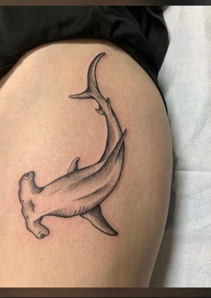 a woman's thigh with a tattoo of a shark on the bottom and side