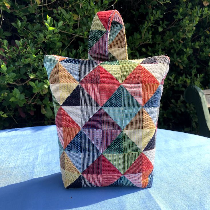 a multicolored bag sitting on top of a blue table