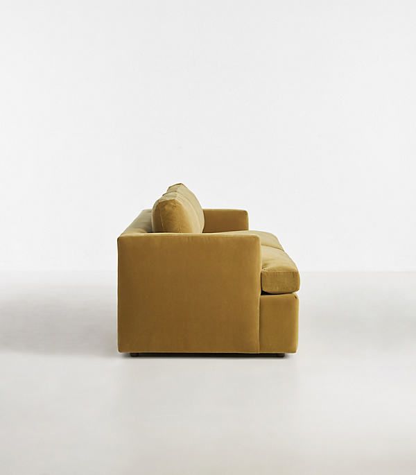 a yellow couch sitting on top of a white floor