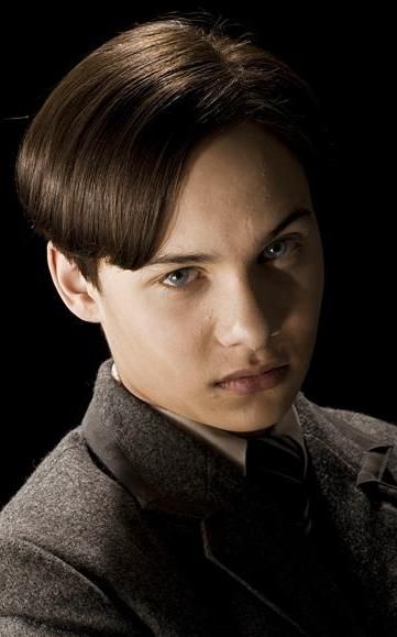 a young man in a suit and tie looking at the camera with an intense look on his face