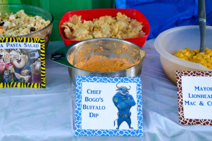 several bowls of food on a table with name tags and place cards for guests to eat