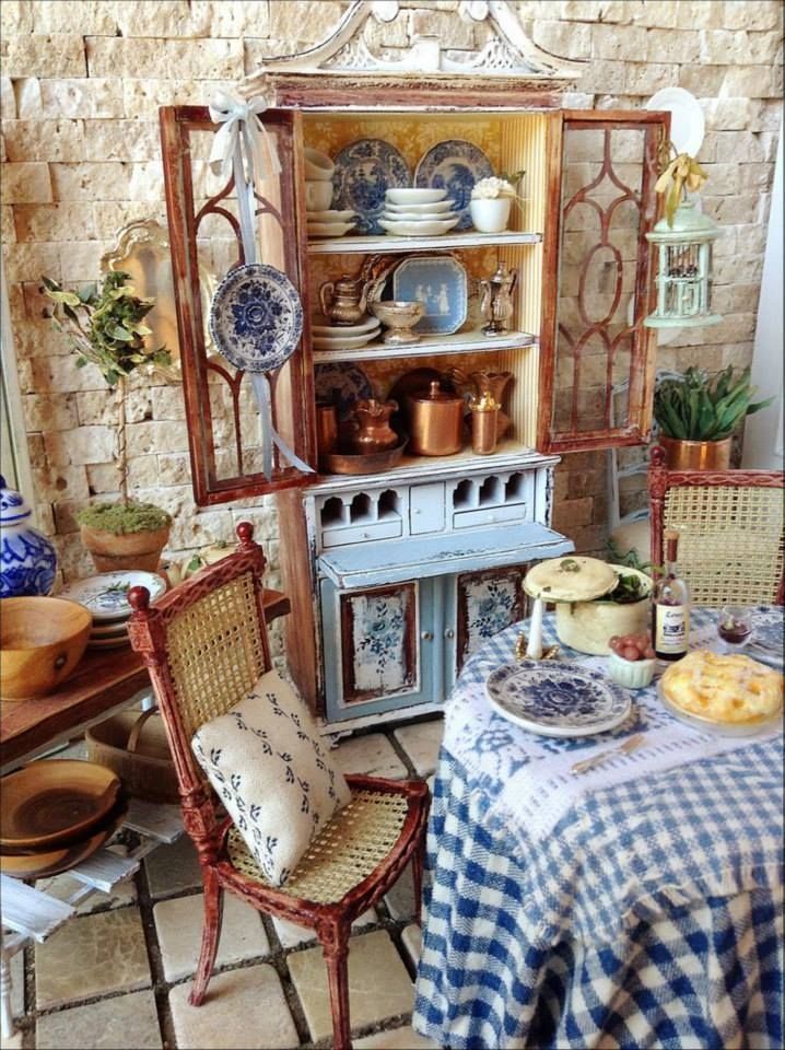 an old fashioned china cabinet with plates and dishes on it's shelves, next to a dining room table